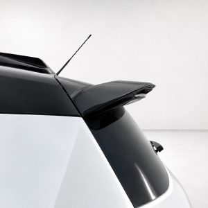Rear view of a white car showing a black roof spoiler and antenna against a pale background