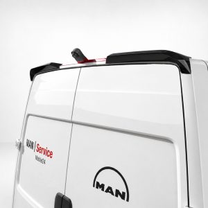 A-563_4jpg - OPSHOLDERS Rear corner of a white MAN van with 'MAN Service Mobile24' branding and a black roof spoiler/antenna on top.