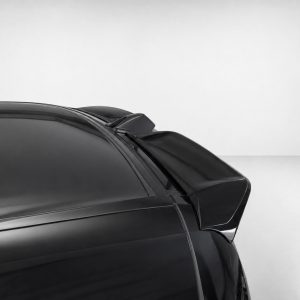 Rear spoiler on a black sports car, close-up against a light gray background