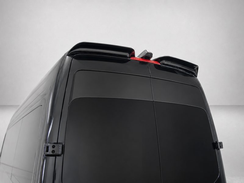 Rear upper section of a black van with roof spoilers and a red third-brake light visible at the top edge.
