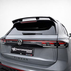 Rear view of a gray Volkswagen Tiguan with a custom Motordrome Design license plate and integrated tail lights under a spoiler