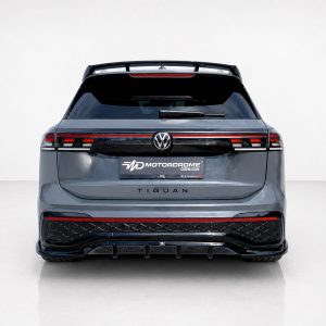 A-565_3jpg - OPSHOLDERS Rear view of a gray Volkswagen Tiguan with a Motordrome Design plate, VW badge, dark taillights, and a sport rear bumper in a studio setting.