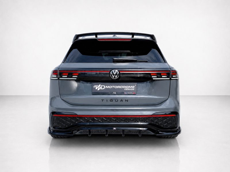 A-565_3jpg - OPSHOLDERS Rear view of a gray Volkswagen Tiguan with a Motordrome Design plate, VW badge, dark taillights, and a sport rear bumper in a studio setting.