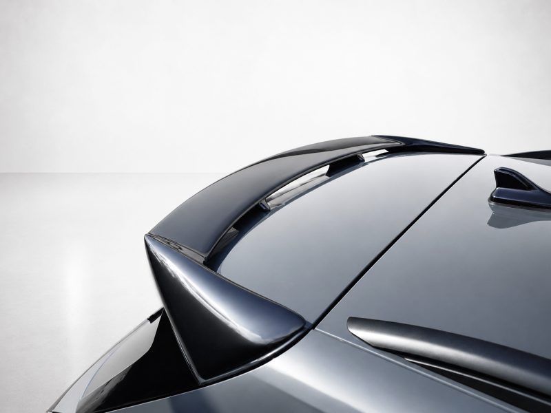 A-565_5jpg - OPSHOLDERS Close-up of a sleek, glossy car roof with a rear spoiler and aerodynamic lines