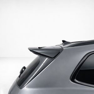 A-565_6jpg - OPSHOLDERS Rear-side view of a gray car hatchback with a prominent spoiler and curved rear window.