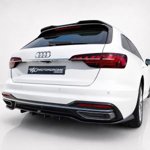 Rear view of a white Audi SUV with a Motordrome Design license plate badge visible on the tailgate