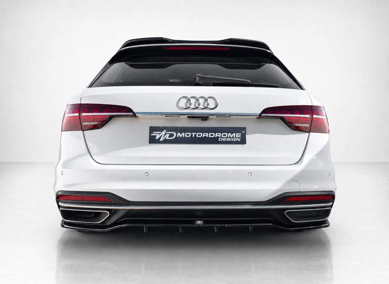 Rear view of a white Audi SUV with dual exhausts and a Motordrome Design license plate panel visible in the center.