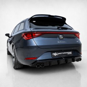 Rear view of a blue SEAT Leon FR hatchback with a rear spoiler and quad exhausts in a studio setting.