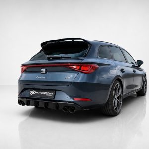 Rear three-quarter view of a blue SEAT Leon FR hatchback in a studio setting, showing quad exhausts and sporty stance
