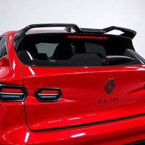 Rear view of a bright red Renault Clio with a black roof spoiler and distinctive split tail lights, showing the Renault badge and model name on the hatch.