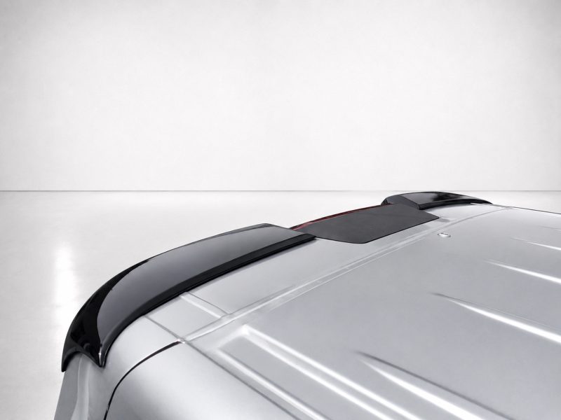 A-575_4jpg - OPSHOLDERS Close-up of the front-right side of a silver car, featuring a dark glass sunroof and glossy hood in a studio setting.