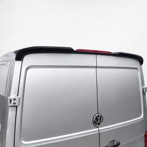 A-575_5jpg - OPSHOLDERS Rear of a silver Volkswagen van with double rear doors, black roof spoiler, and a red high-mounted brake light above the doors. The VW emblem is visible on the tail gate.
