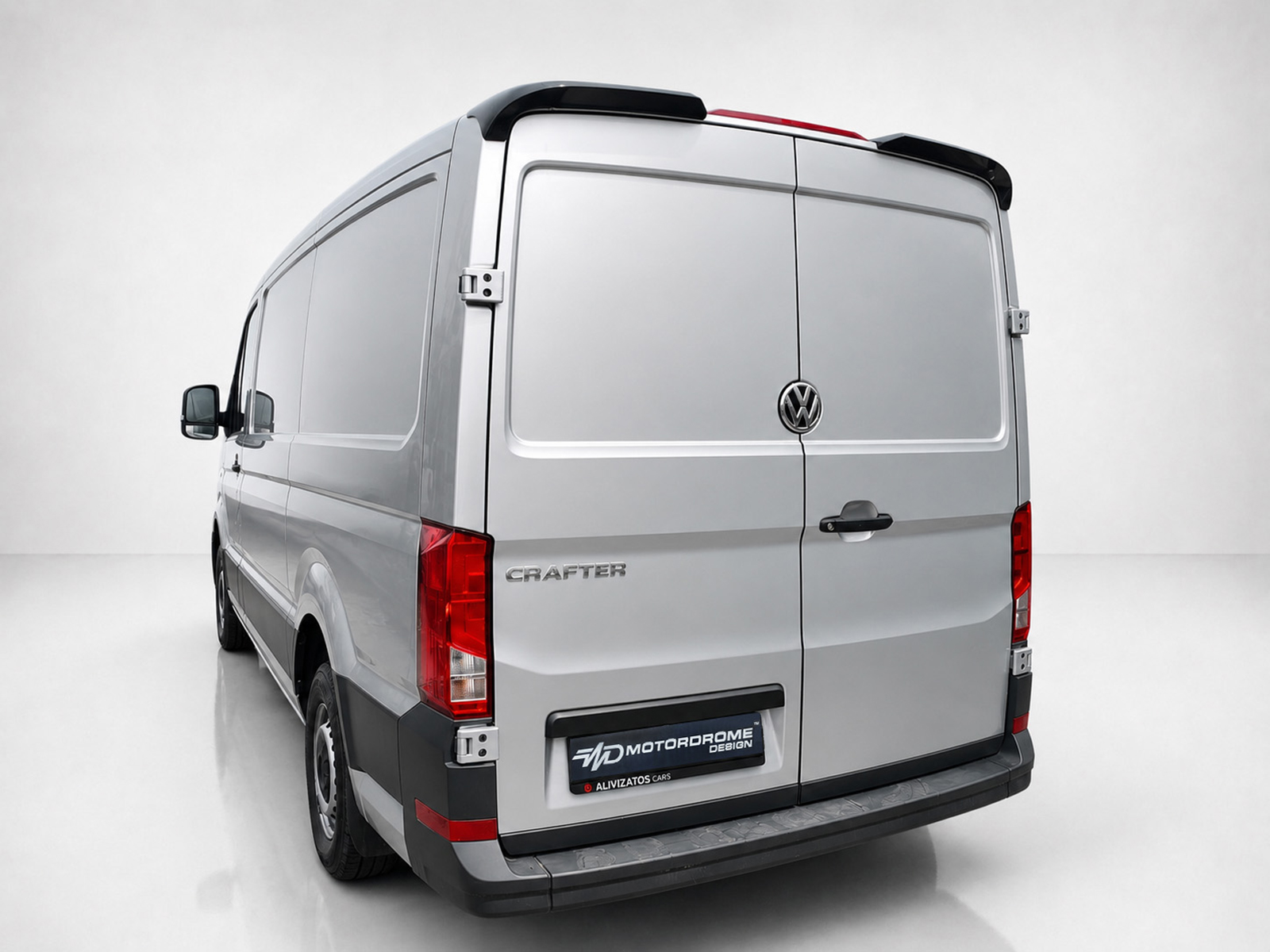A-576_2jpg - OPSHOLDERS Rear view of a silver Volkswagen Crafter cargo van with dual doors and prominent VW emblem in a studio setting, showing red taillights and plastic bumper.