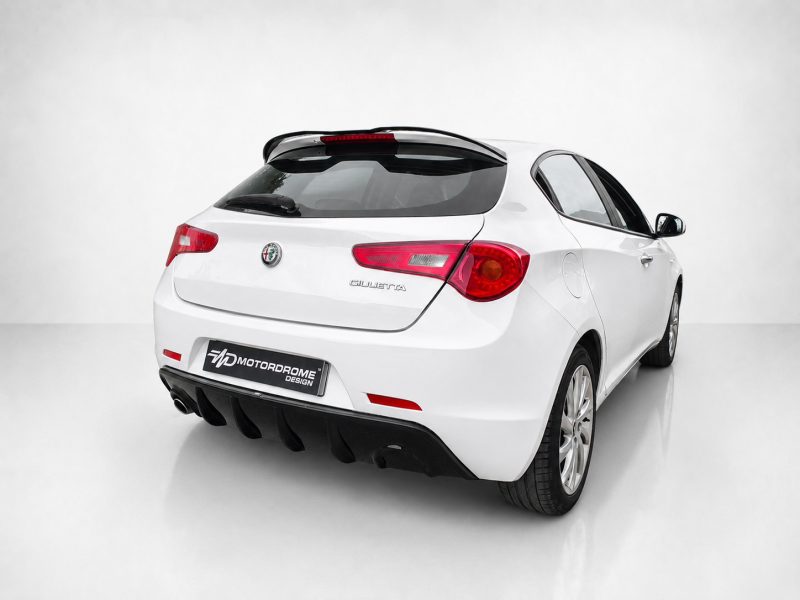 Rear three-quarter view of a white Alfa Romeo Giulietta in a studio setting with a clean gray backdrop