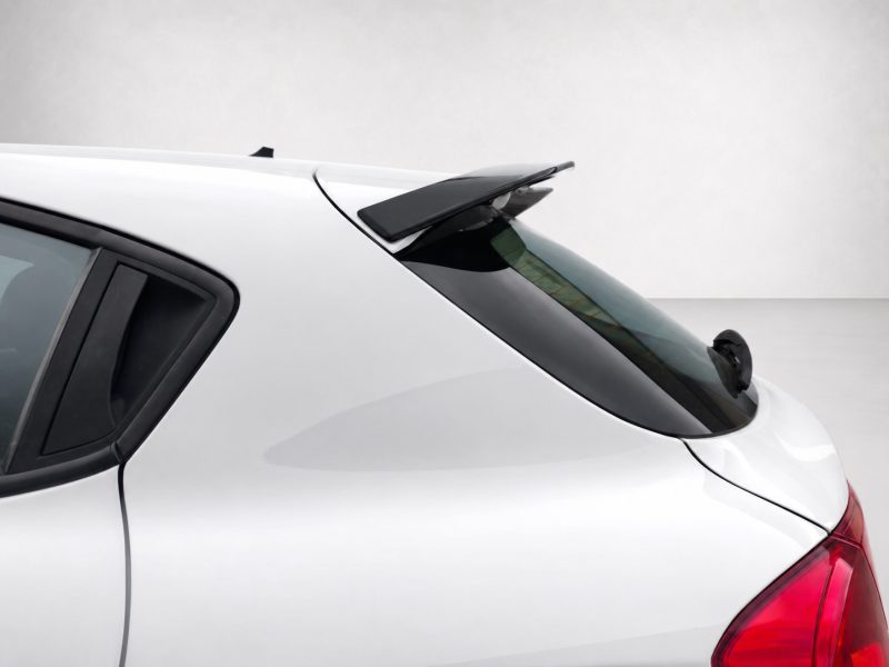 White car rear end with a black spoiler mounted on the tailgate above the rear window.