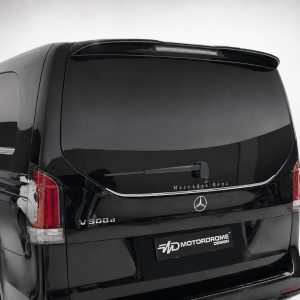 Rear view of a black Mercedes‑Benz V300d van with dark tinted windows and a MotorDrome Design plate on the bumper edge to the right of the emblem.
