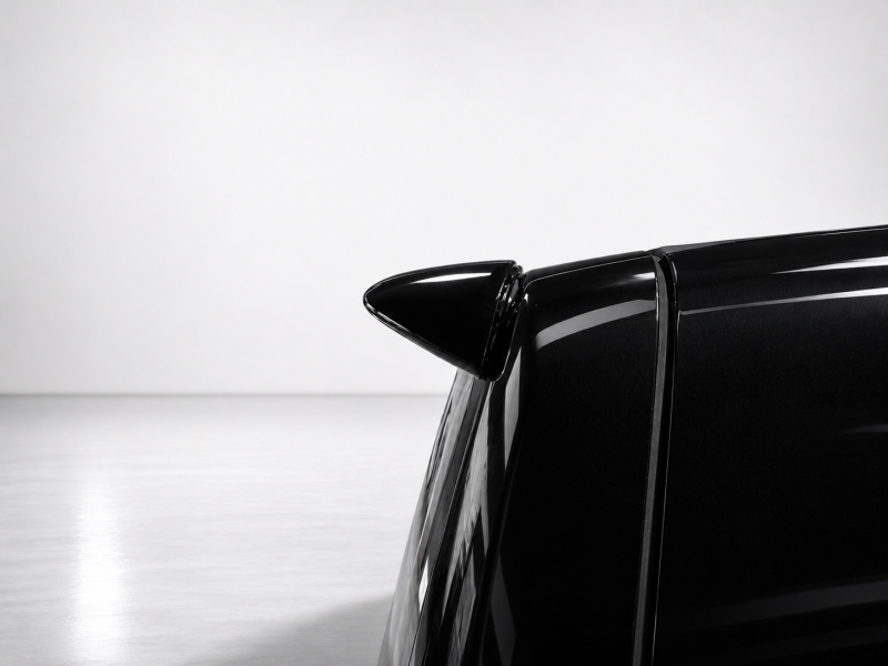 A-578_5png - OPSHOLDERS Close-up of a black car's rear spoiler against a light gray background