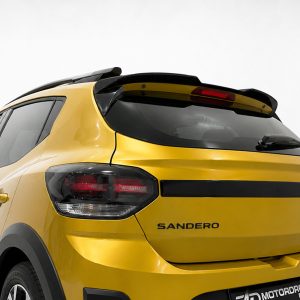Rear view of a yellow Sandero hatchback with black trim, showing taillights and rear window wiper on a light background