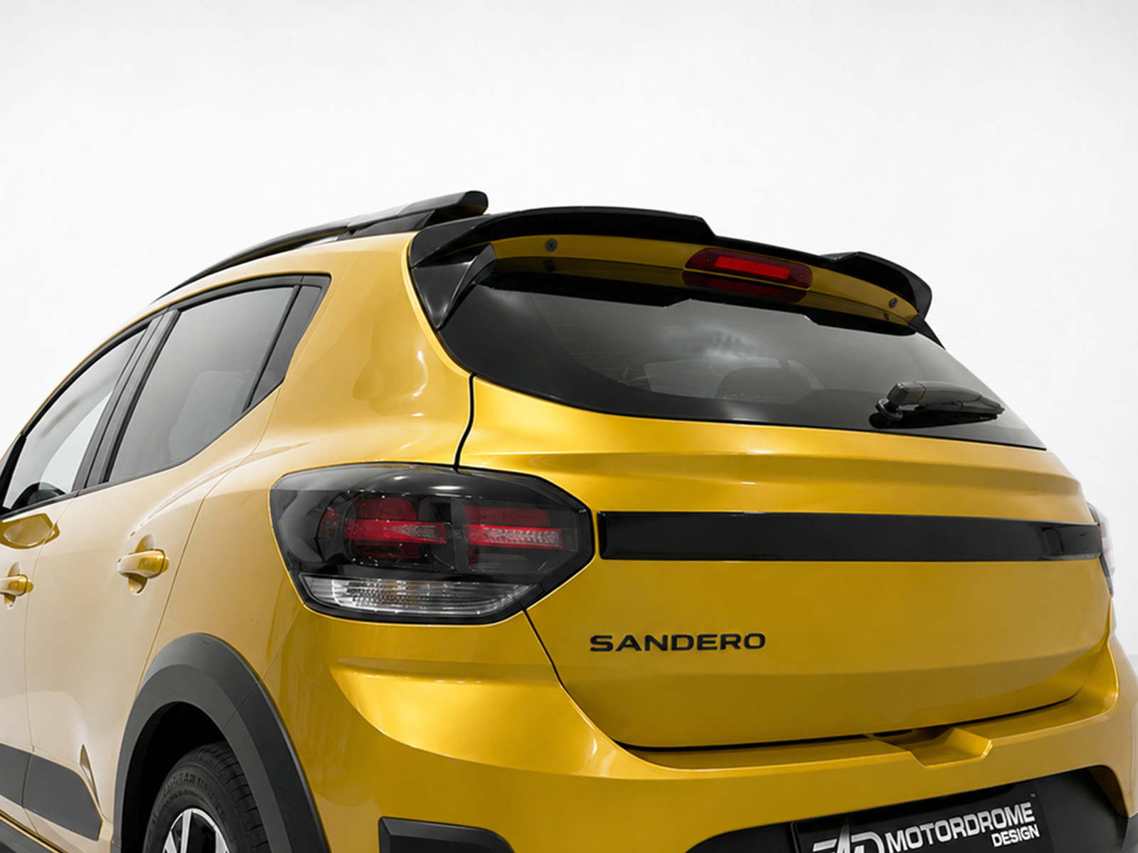 A-579_1jpg - OPSHOLDERS Rear view of a yellow Sandero hatchback with black trim, showing taillights and rear window wiper on a light background