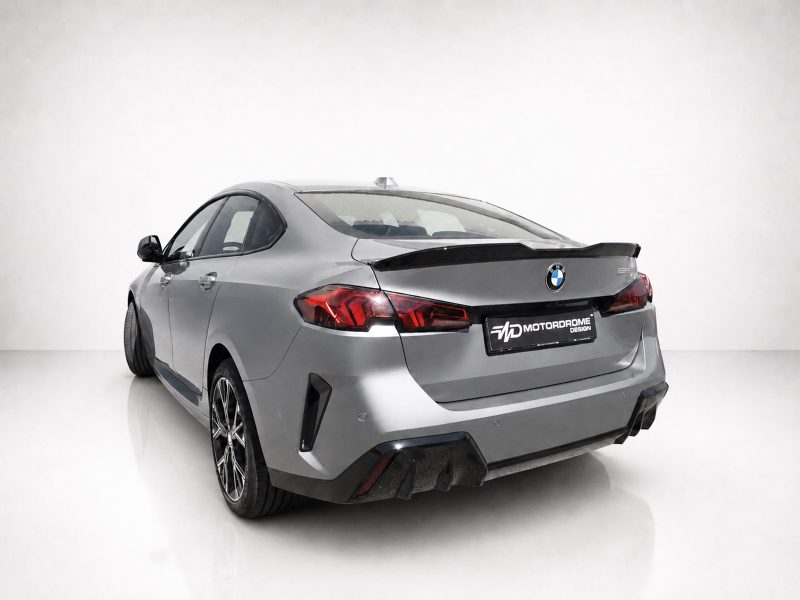 A-581_3jpg - OPSHOLDERS Silver BMW sedan shown from rear-three-quarters with a large black spoiler and MD Motordrome Design license plate area