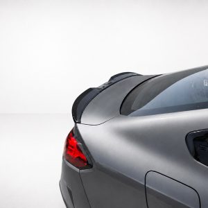 A-581_4jpg - OPSHOLDERS Rear view of a silver car showing the trunk, taillight, and curved rear window against a light background.