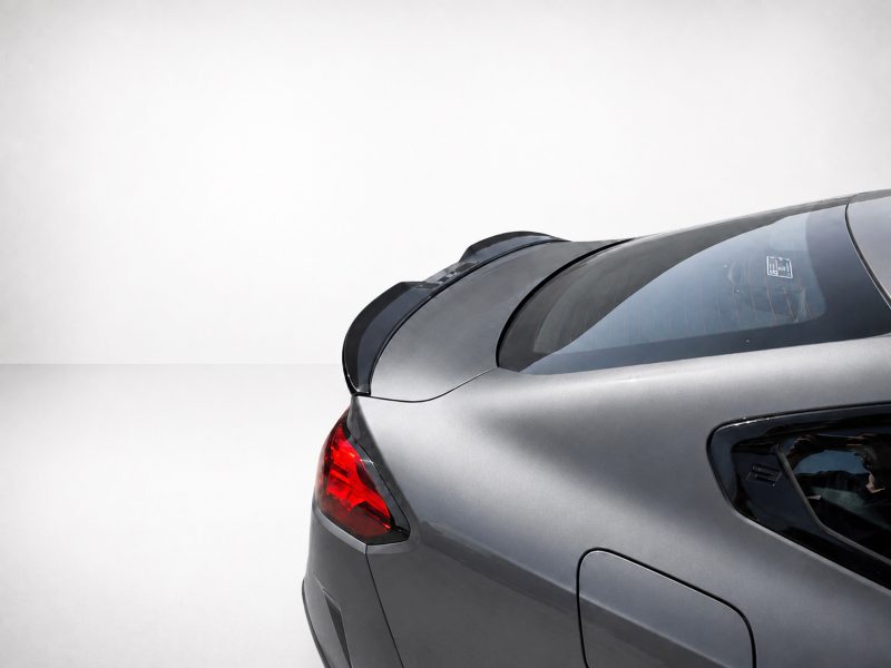A-581_4jpg - OPSHOLDERS Rear view of a silver car showing the trunk, taillight, and curved rear window against a light background.