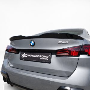 A-581_5jpg - OPSHOLDERS Rear of a silver BMW 320 with a black spoiler and red taillights, displaying a MD Motordrome Design plate