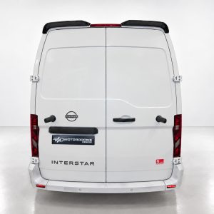 White Nissan Interstar van rear view with two rear doors, red taillights, and logo badges (Nissan, MotorDrome Design) visible on the back.