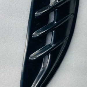 Glossy black automotive vent trim with three horizontal slats on a curved panel.