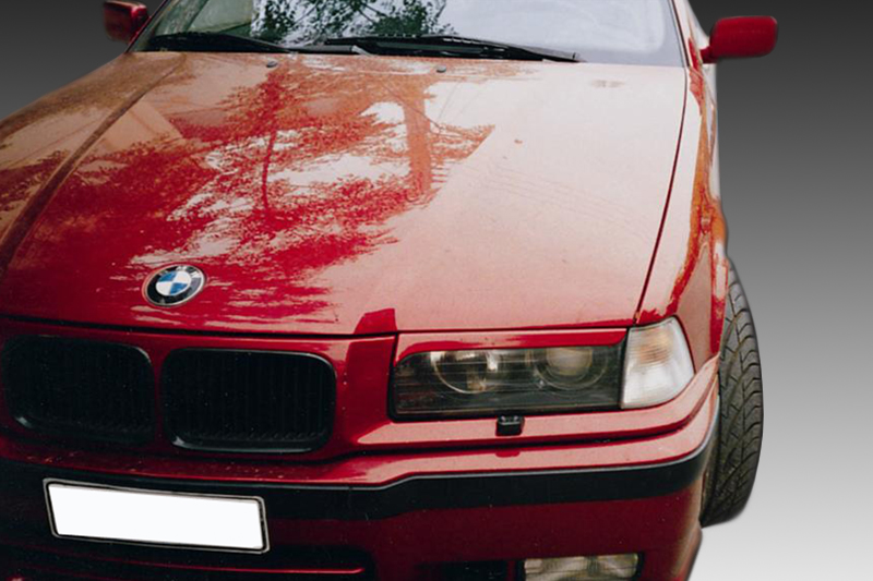 FR000007_1jpg - OPSHOLDERS Close-up of a red BMW car's front end, showing the grille, headlight, and hood with reflections