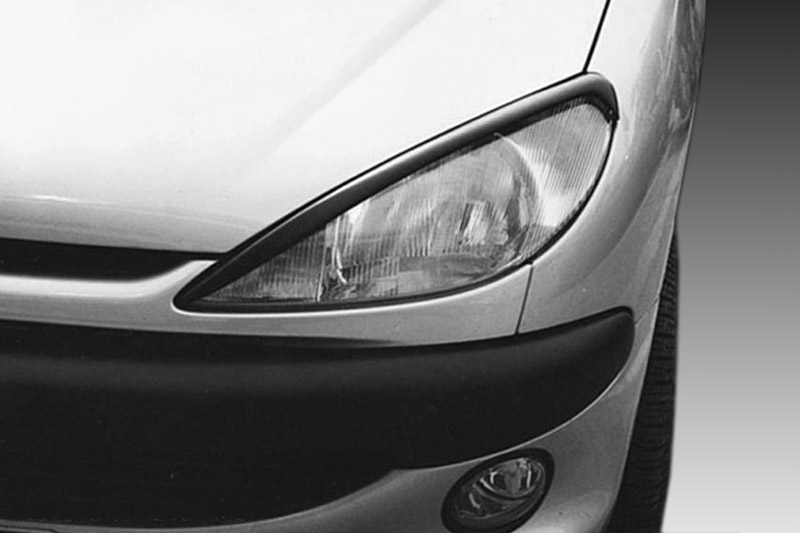 FR000024_1jpg - OPSHOLDERS Close-up of the front left corner of a silver car, showing the headlight, bumper, and fog light.