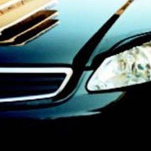 Close-up of a dark blue car's front end, featuring the grille and right headlight.