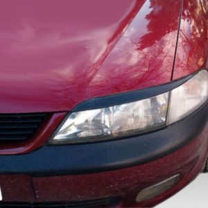 Close-up of the front end of a red car, showing the headlight, grille, and bumper.