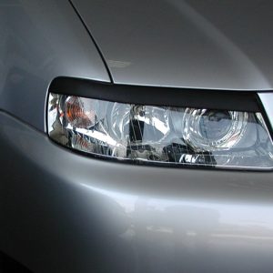 Close-up of a silver sedan's front left headlight with clear lens and reflectors