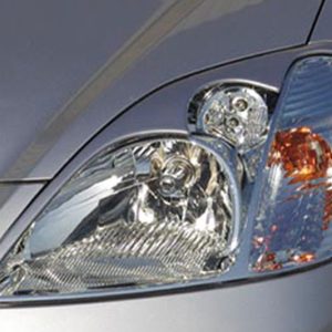 Close-up of a car headlight assembly on a silver vehicle, showing the main lamp and turn signal