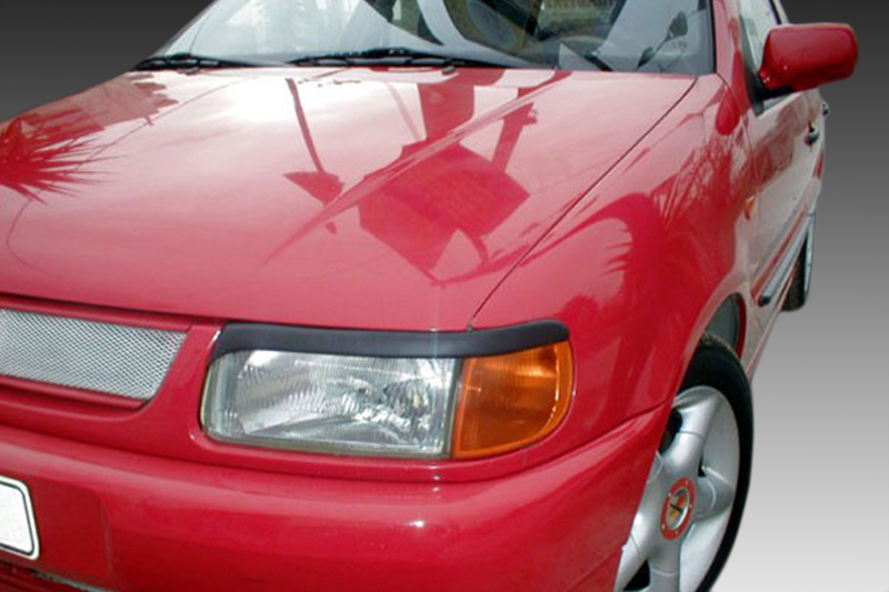 FR000064_1jpg - OPSHOLDERS Close-up of a red car's front end, showing a headlight, orange turn signal, grille, and part of the front left wheel.