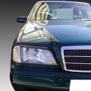 Front view of a dark green Mercedes-Benz car, showing the grille and hood emblem with reflections on the hood.