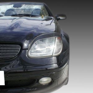 Front view of a black Mercedes convertible, showing the grille, headlight, and lowered bumper against a gray gradient background.