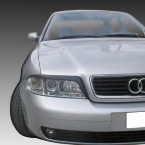 Front-left view of a silver Audi car showing its grille with four rings and headlight detail, license plate blurred out.