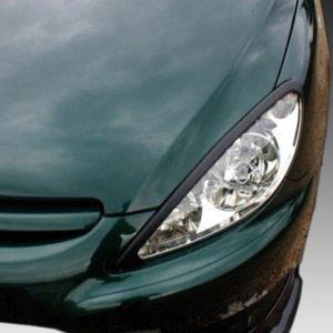 Front-left corner of a dark green car, featuring its headlight and partial grille/bumper area.