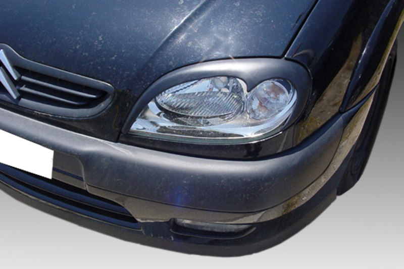 FR000083_1jpg - OPSHOLDERS Front end of a dark car showing the headlight, grille, and bumper (license plate obscured).