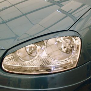 Close-up of a teal car's front headlight on the left side, with reflections on the hood.
