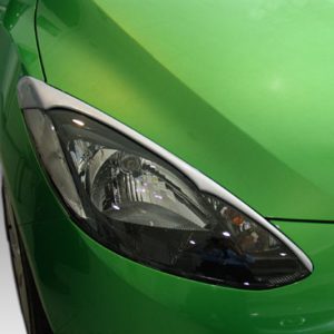 Close-up of a bright green car's headlight and front fender, showing the sleek design and glossy paint.