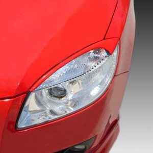 Front-left headlight and grille of a red car, close-up view