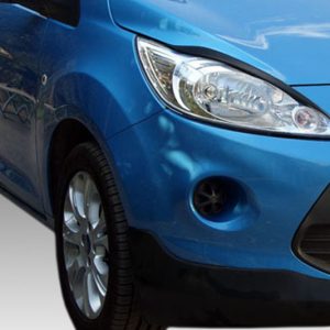 Close-up of a blue car's front end, showing the headlight, grille, and front wheel-on-view.