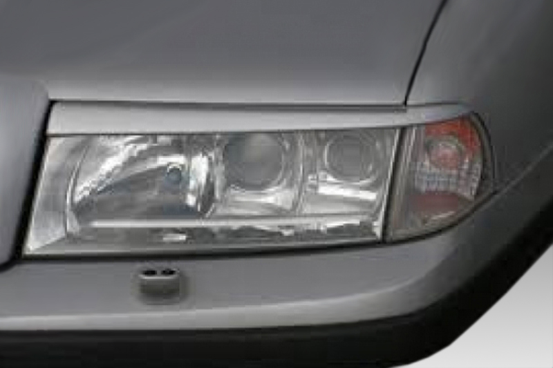 FR000128_1jpg - OPSHOLDERS Front right headlight of a gray car, showing the headlamp and turn signal in the bumper area near the hood edge.