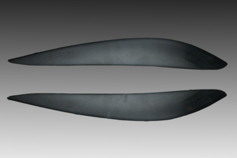 FR000142_1jpg - OPSHOLDERS Two dark gray curved blade-like shapes laid flat against a gradient gray background at the top and bottom of the image.