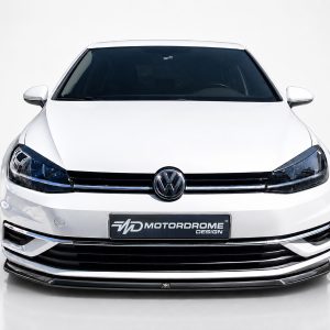 FR000144_2jpg - OPSHOLDERS Front view of a white Volkswagen car in a studio setting, showing the grille, emblem, and headlights against a light background.