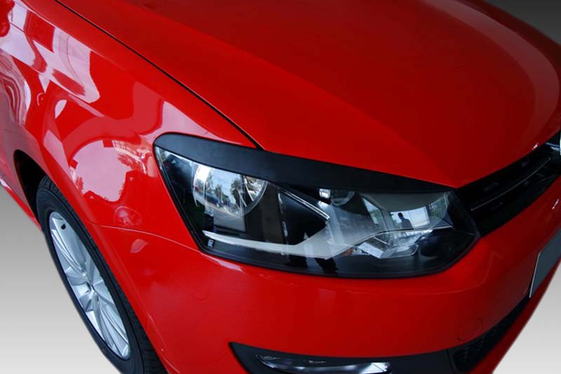 FR000145_1jpg - OPSHOLDERS Close-up of a red car's front-left corner, showcasing the headlight and glossy paint finish in sunlight