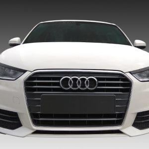 Front view of a white Audi sedan with a large black grille and four-ring emblem in the center, set against a gray gradient background.